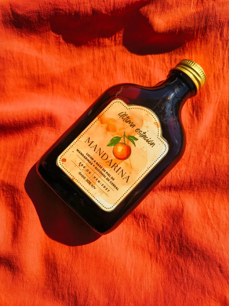Licor artesanal de mandarina de Última Estación en vista lateral, con la etiqueta a la vista