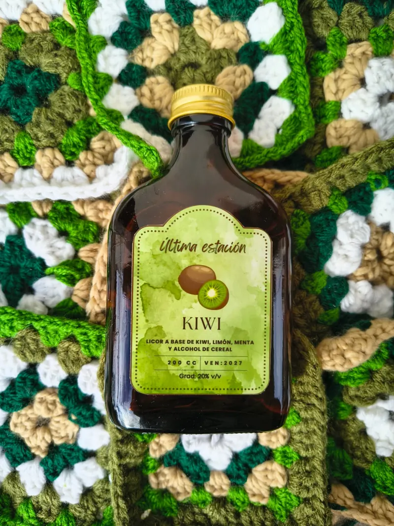 Botella de licor artesanal de kiwi de Última Estación sobre un tejido verde y blanco al crochet