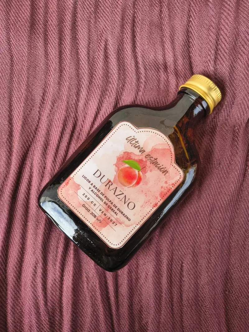 Licor artesanal de durazno de Última Estación en vista lateral, con la etiqueta a la vista